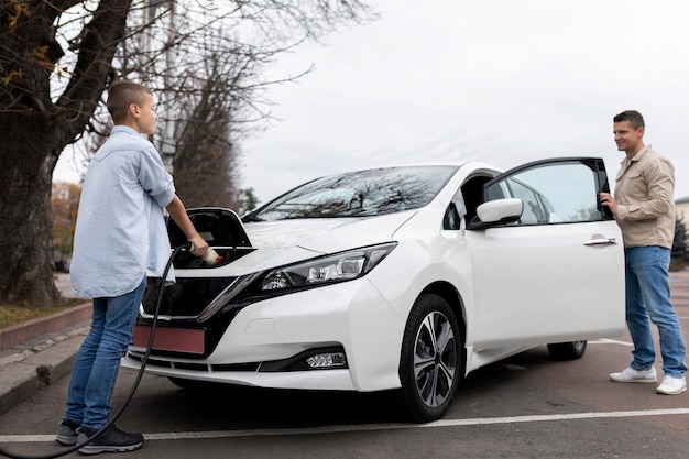 Garçon et papa près d'une voiture électrique