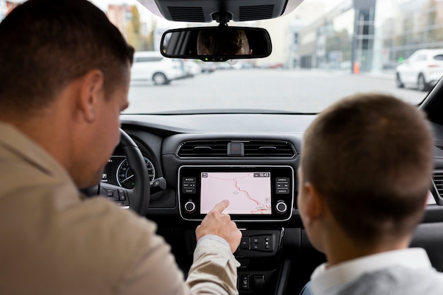 Garçon et papa près d'une voiture électrique