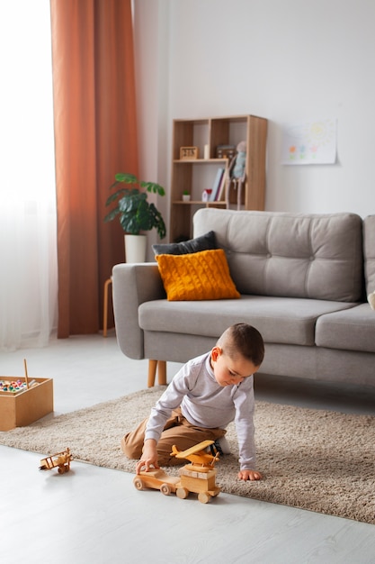 Photo gratuite garçon plein coup jouant à la maison