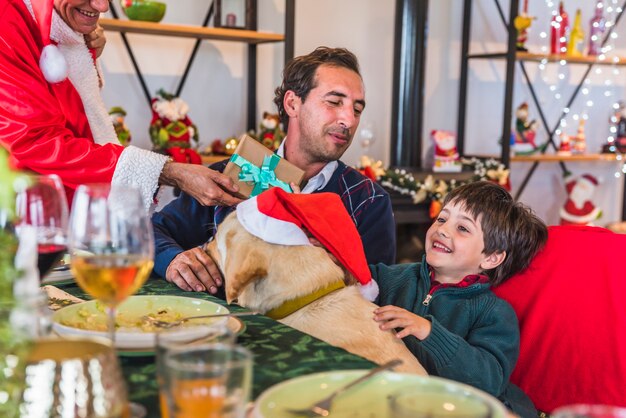 Photo gratuite garçon prenant une boîte-cadeau du père noël