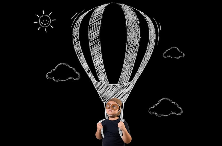 Photo gratuit le garçon prétend être un super-héros et volera avec un ballon.