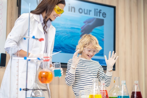 Garçon regardant des flacons avec du liquide et un enseignant