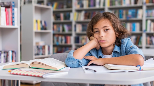 Photo gratuite garçon s'ennuie pendant qu'il fait ses devoirs avec copie espace