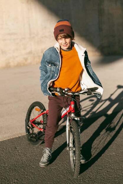 Garçon avec son vélo en plein air dans la ville