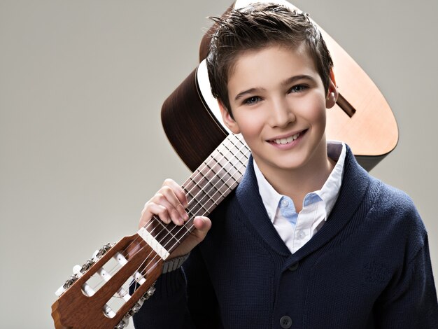 Garçon souriant avec guitare.