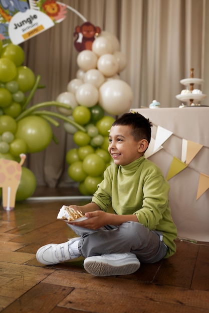 Garçon souriant plein coup avec gâteau