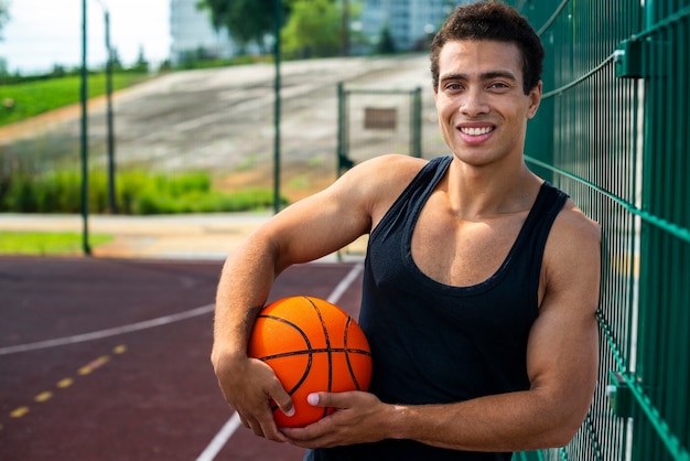 Garçon souriant posant pour la caméra avec un ballon