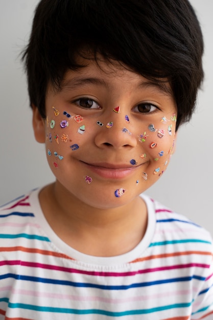 Garçon souriant vue de face avec des autocollants sur le visage