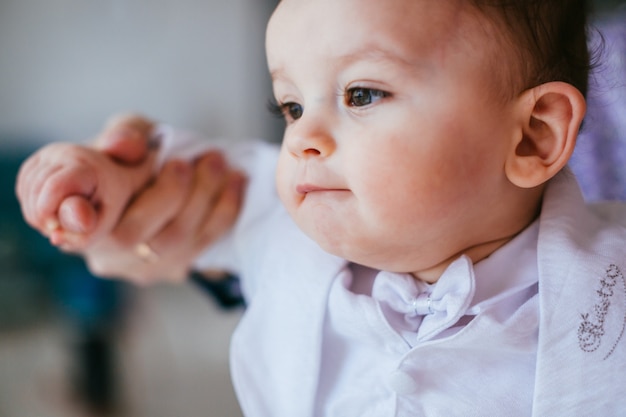 Le garçon de tendresse assis sur le lit