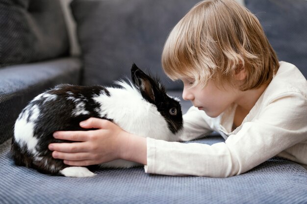 Garçon de tir moyen avec lapin mignon