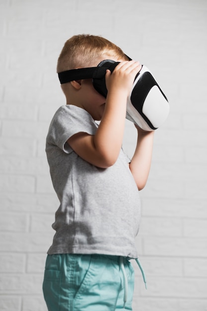 Garçon utilisant un casque virtuel à la maison