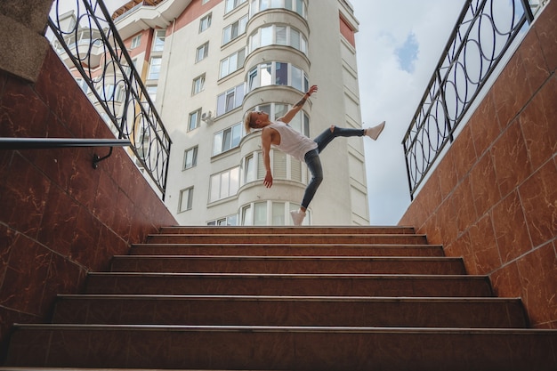 Garçon de la ville élégante dansant, pratiquant le saut