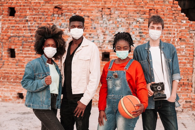 Garçons et filles posant avec des masques chirurgicaux