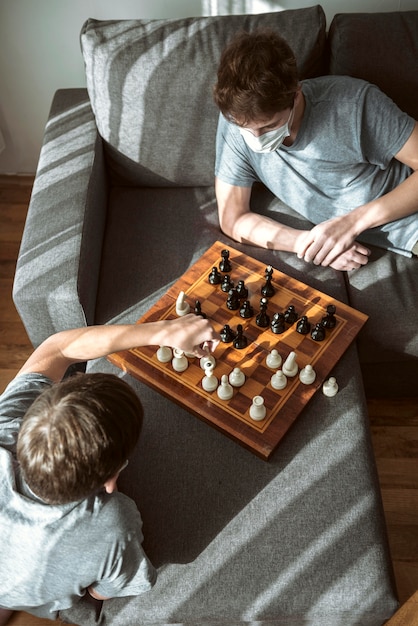 Garçons en quarantaine à angle élevé jouant aux échecs