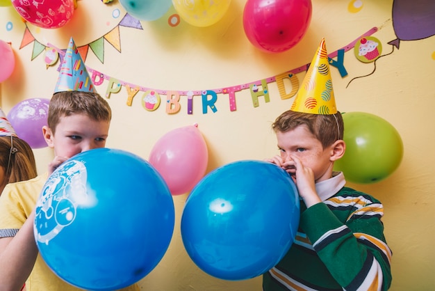 Photo gratuite garçons soufflant des ballons