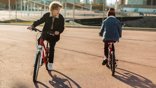 Photo gratuite les garçons à vélo à l'extérieur dans le parc de la ville