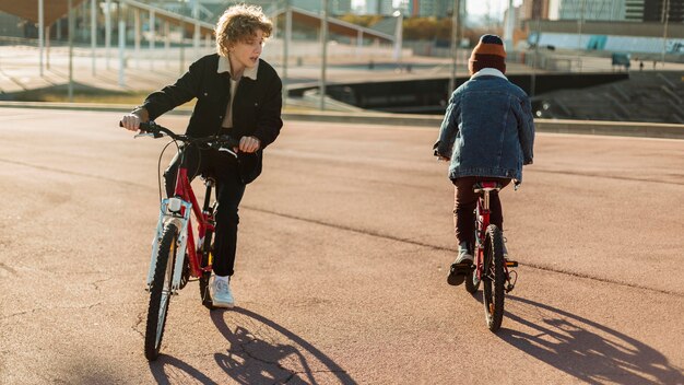 Les garçons à vélo à l'extérieur dans le parc de la ville
