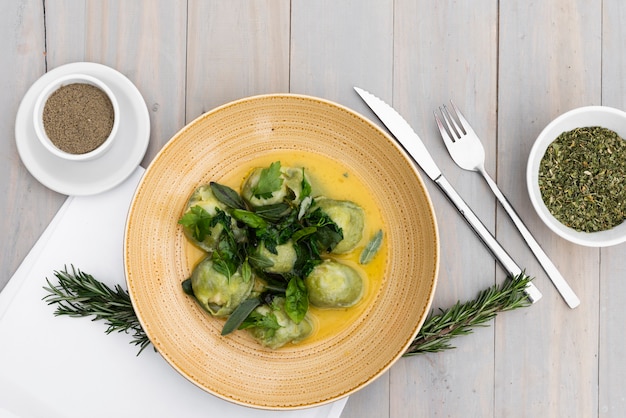 Photo gratuite garnir les pâtes raviolis aux herbes et épices sur une table en bois