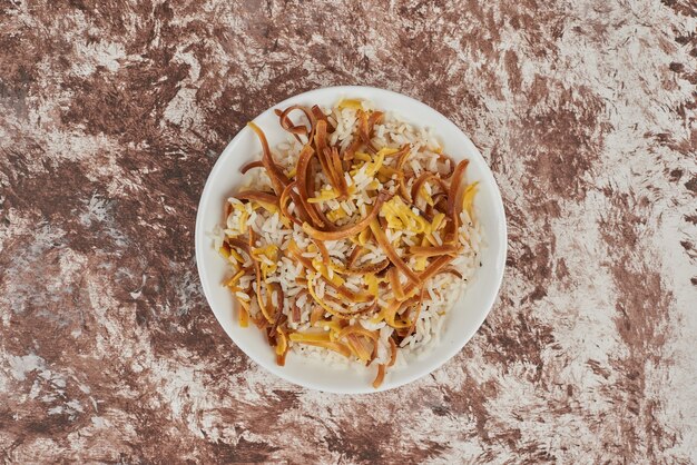 Garnir de riz dans une assiette blanche.