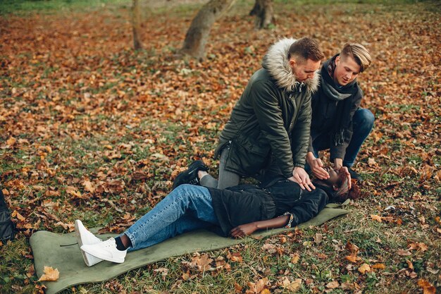 Les gars aident une femme. Fille africaine est inconsciente. Fournir les premiers soins dans le parc.