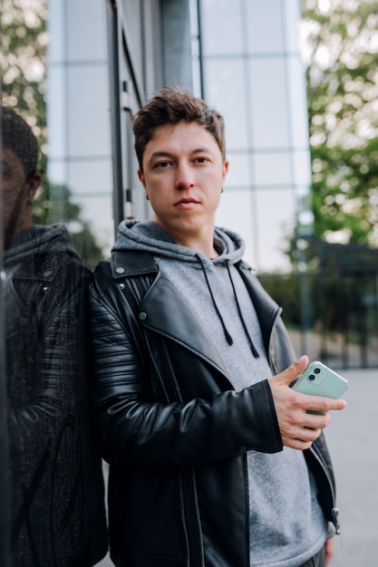 Gars élégant avec smartphone dans la ville.