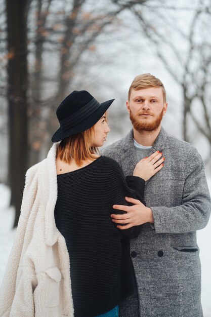 Le gars et la fille se reposent dans la forêt en hiver.