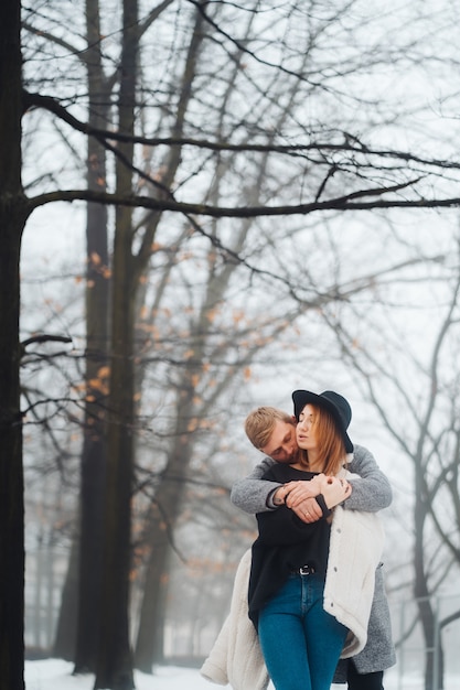 Le gars et la fille se reposent dans la forêt en hiver.