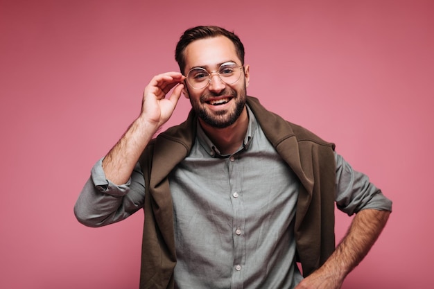 Un gars intelligent en tenue marron porte des lunettes et regarde la caméra