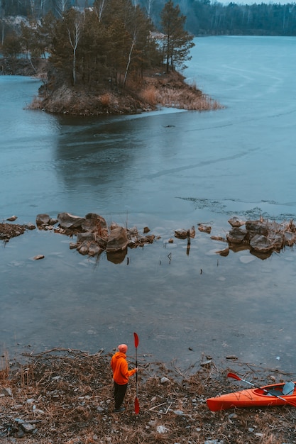 Photo gratuite le gars se tient au bord du lac gelé