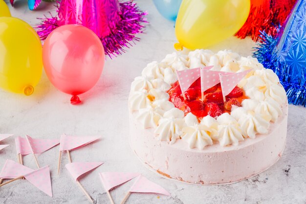 Gâteau d&#39;anniversaire avec des drapeaux au milieu de décorations