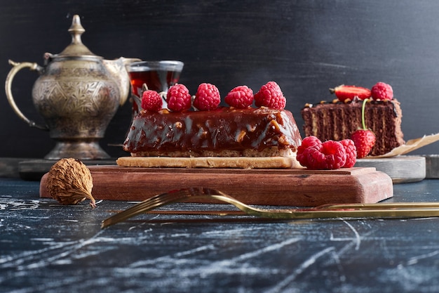 Gâteau au chocolat aux framboises sur une planche de bois.