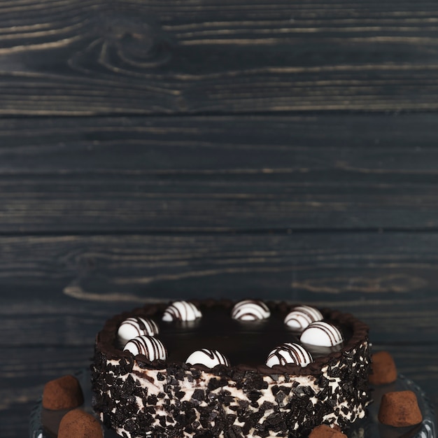 Photo gratuite gâteau au chocolat devant un tableau en bois