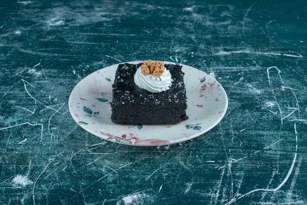 Gâteau au chocolat sur un plateau sur bleu.