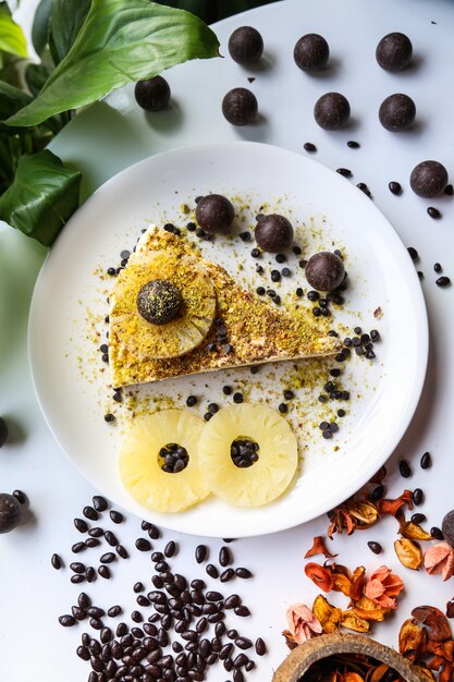 Gâteau au fromage avec ananas et boules de chocolat sur une assiette