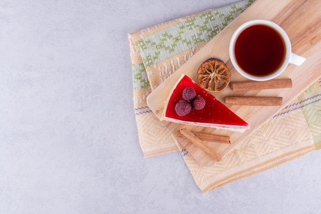 Gâteau au fromage et tasse de thé noir sur planche de bois. photo de haute qualité