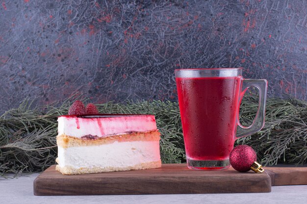 Gâteau au fromage et verre de thé sur planche de bois avec décorations festives. photo de haute qualité