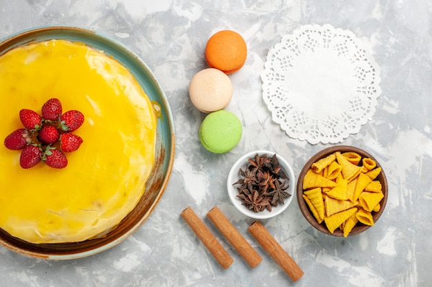 Gâteau au sirop jaune vue de dessus avec des macarons français sur fond blanc