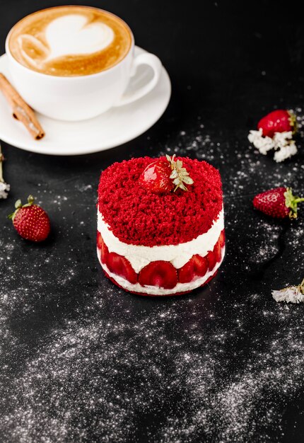 Gâteau aux fraises et tasse de cappuccino sur la table