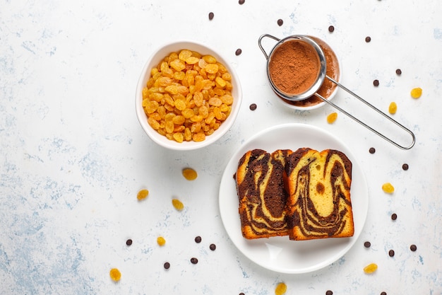 Gâteau aux raisins secs en tranches de gâteau aux raisins secs et cacao en poudre, vue du dessus