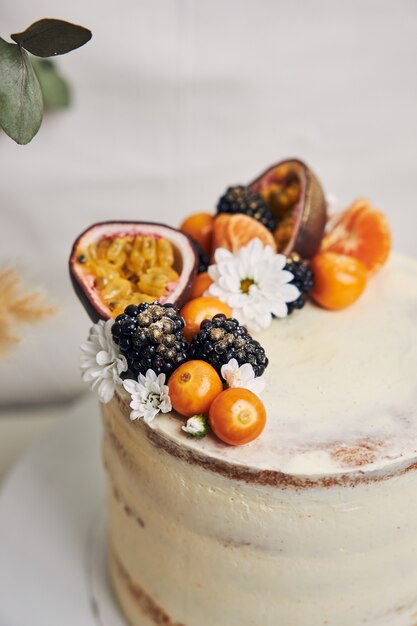 Gâteau blanc aux baies et fruits de la passion à côté d'une plante