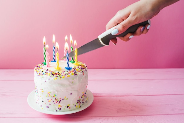 Gâteau coupant à la main avec des bougies