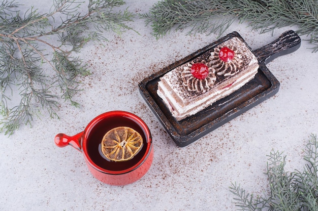 Gâteau crémeux à bord noir avec une tasse de thé.