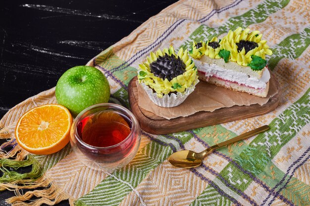 Gâteau avec décoration de style tournesol sur une planche de bois avec du thé.