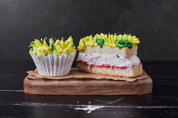 Gâteau avec décoration de style tournesol sur une planche de bois.