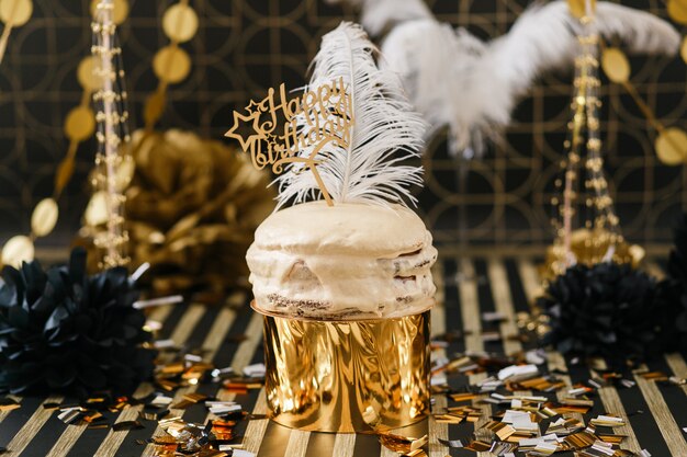 Gâteau de fête d&#39;anniversaire avec décor doré et noir divers ballons.