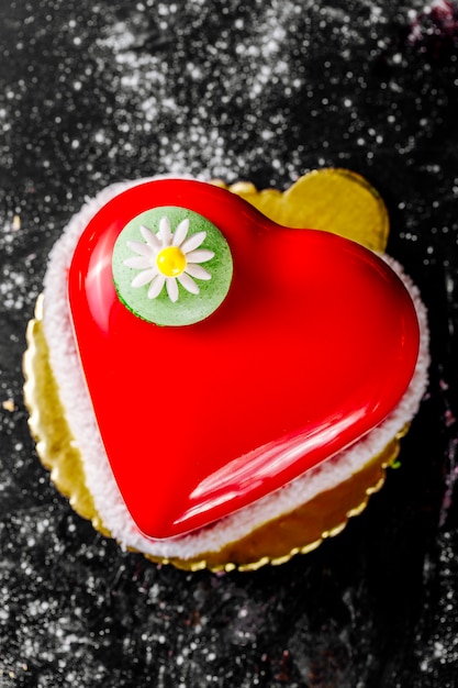 Photo gratuite gâteau en forme de coeur avec garniture rouge orné de camomille