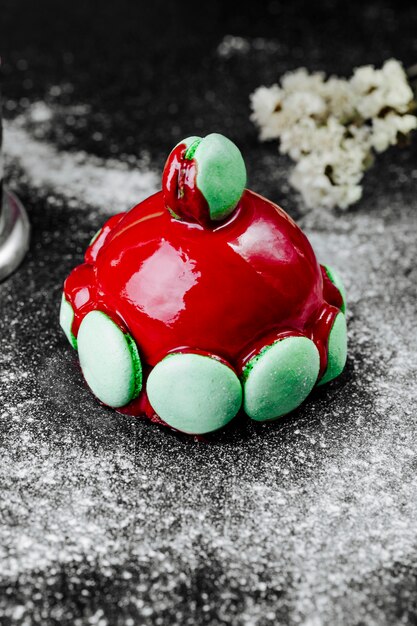 Gâteau avec garniture rouge et macarons