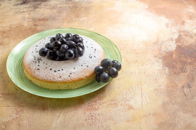 un gâteau un gâteau appétissant avec du sucre en poudre de raisins noirs sur la plaque