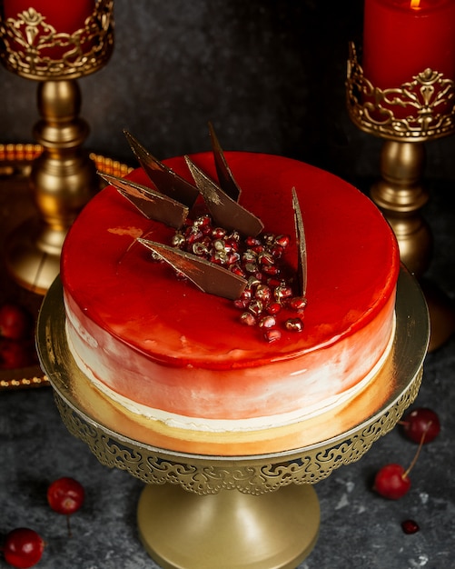 Gâteau glacé rouge avec des triangles de grenade et de caramel