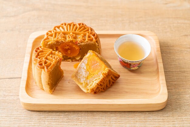 Gateau De Lune Chinois Au Durian Et Saveur De Jaune D Oeuf Avec Du The Sur Une Plaque De Bois Photo Premium
